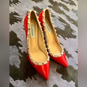 Red patent leather pumps adorned w/beige piping and metal studs.Pointed toe.New